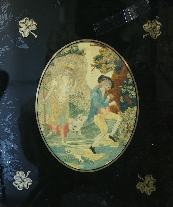 Two early 19th century oval silk worked embroideries. Both figural pastoral scenes, mostly worked in stem stitch, the leaves in a stump work style knotting. Both embroideries set within decorative Verre Eglomise glass an